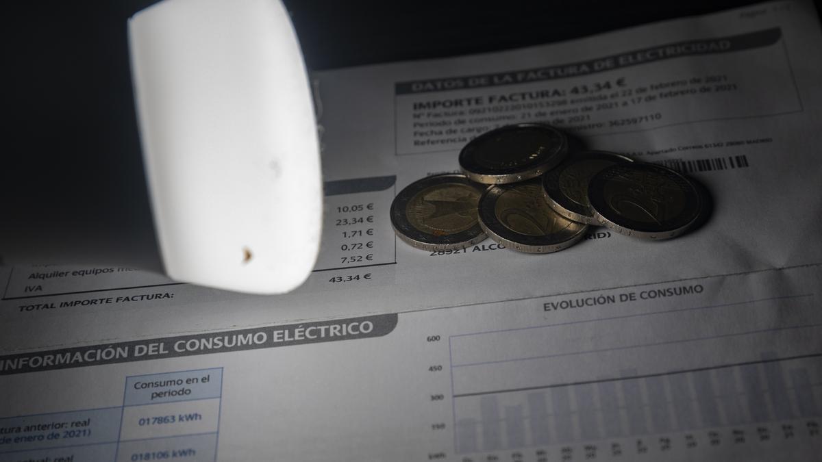 Archivo - Una lámpara refleja el importe de una factura el día en que el precio de la luz ha marcado un mínimo por primera vez en dos meses, a 27 de diciembre de 2021, en Madrid, (España). El precio medio de la electricidad en el mercado mayorista registr