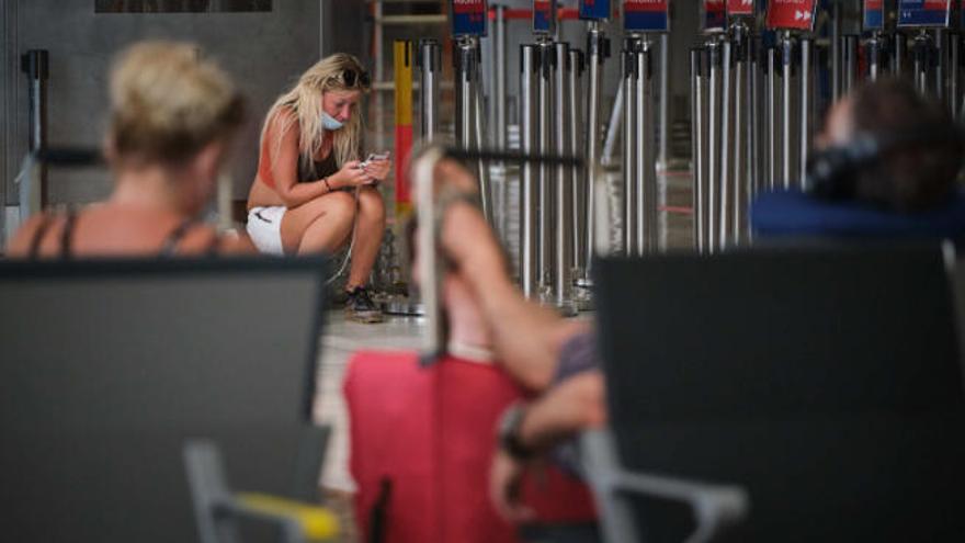 Una turista consulta su teléfono en el aeropuerto del Sur.