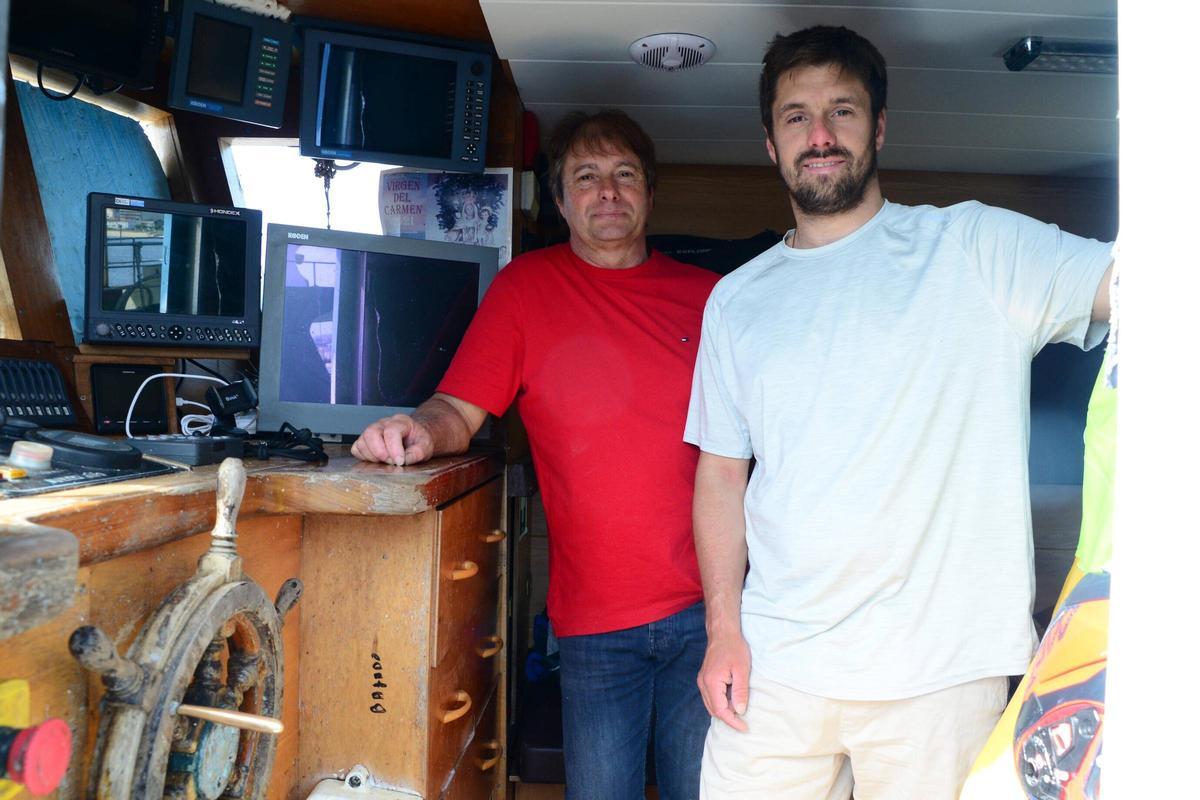 Los marineros dentro de la embarcación atracada en Cangas.