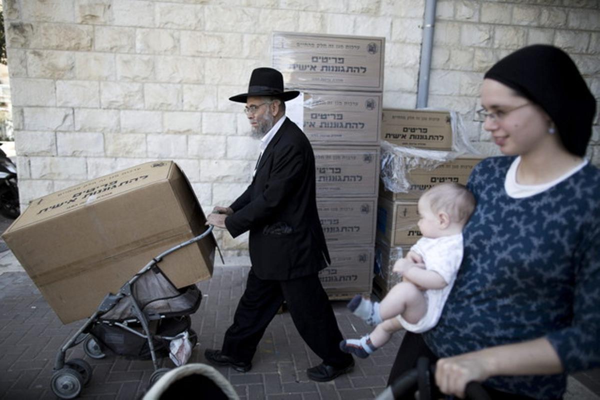 Un ultraortodox jueu recull una caixa amb màscares antigàs a Jerusalem.