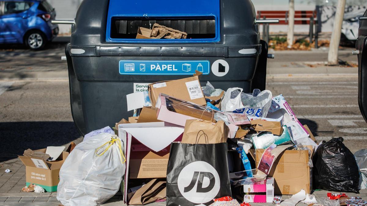 Un contenedor de papel a rebosar de paquetes de regalo.
