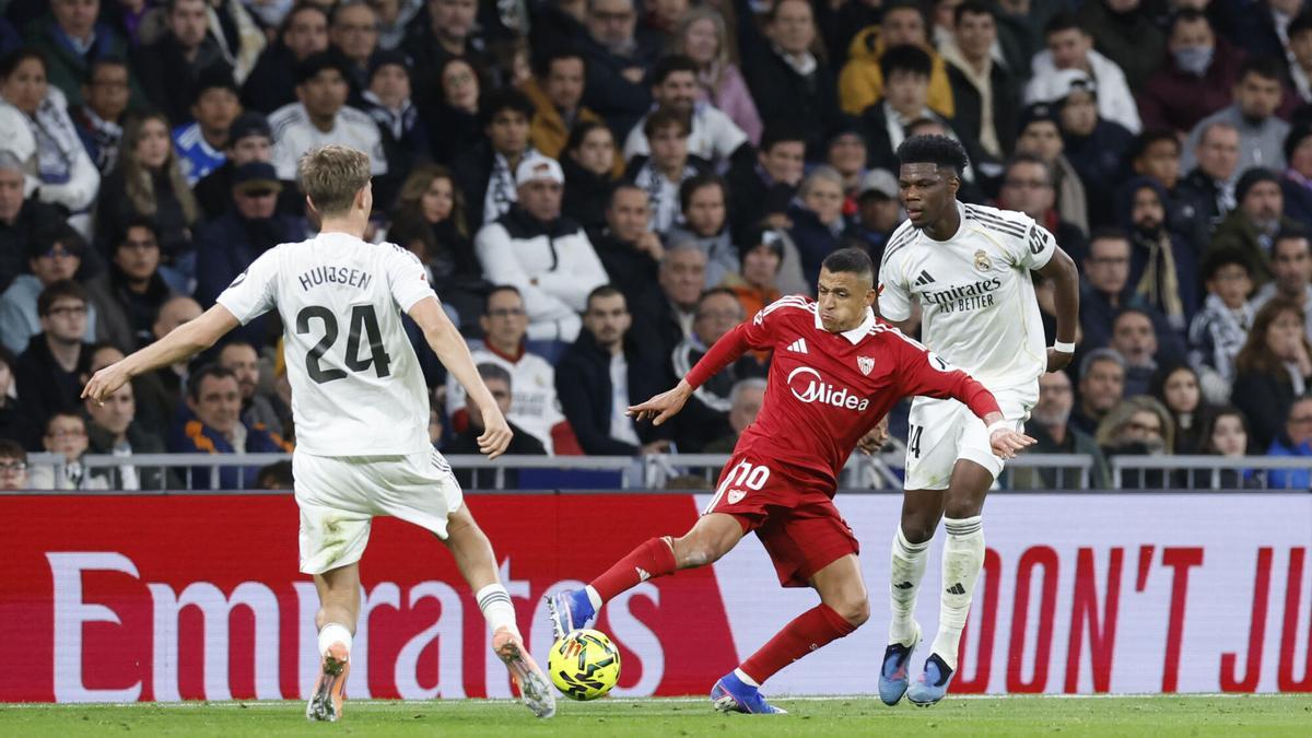 Alexis Sánchez lucha un balón ante Huijsen y Tchouameni en el Real Madrid-Sevilla FC de LaLiga EA Sports.