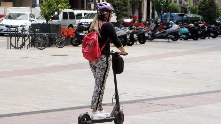 Una joven conduce un patinete en Vigo. // Marta G. Brea