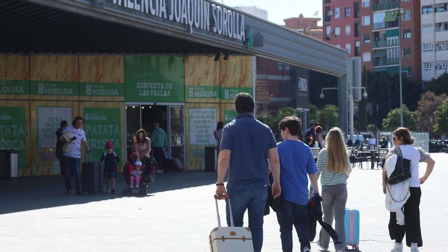 Varias familias, en los accesos a la estación Joaquín Sorolla, ayer en València. | JM LÓPEZ