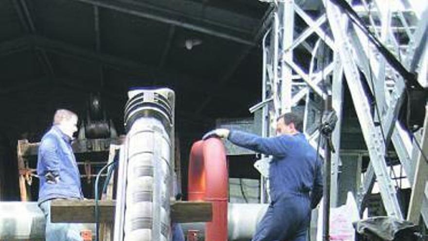 Los operarios preparan las tuberías que recogen el agua de las minas.