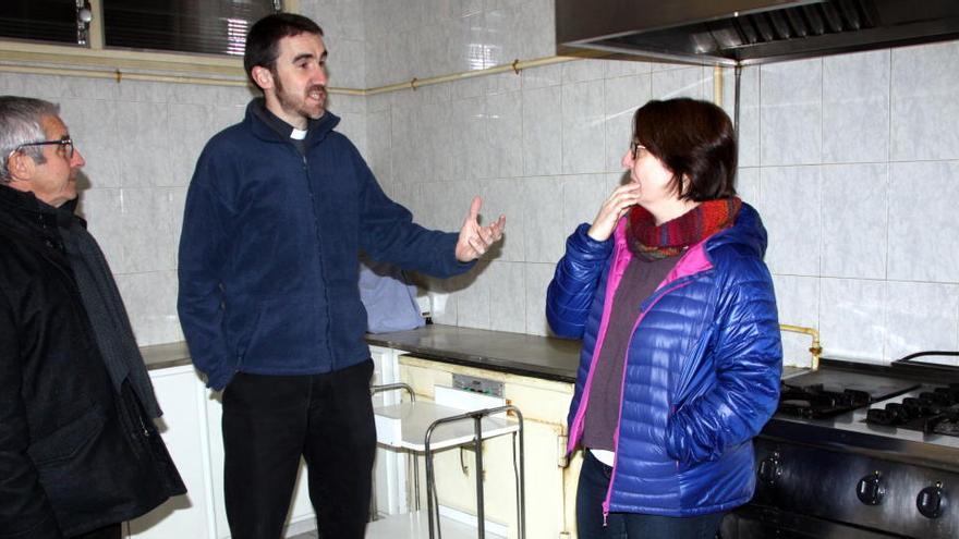 Marc Majà i Guiu, al centre de la fotografia, acompanyat pel director de Càritas Diocesana, Josep Vidal, i la treballadora social de Càritas, Gemma Bajona, a la cuina de la casa de Les Vetlladores en una imatge del 18 de gener