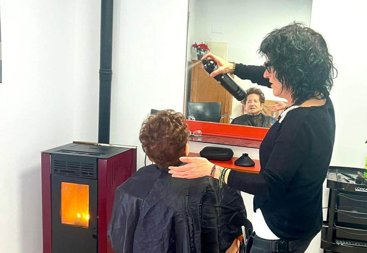 Esther Angulo peina a una señora en un pueblo de Burgos.