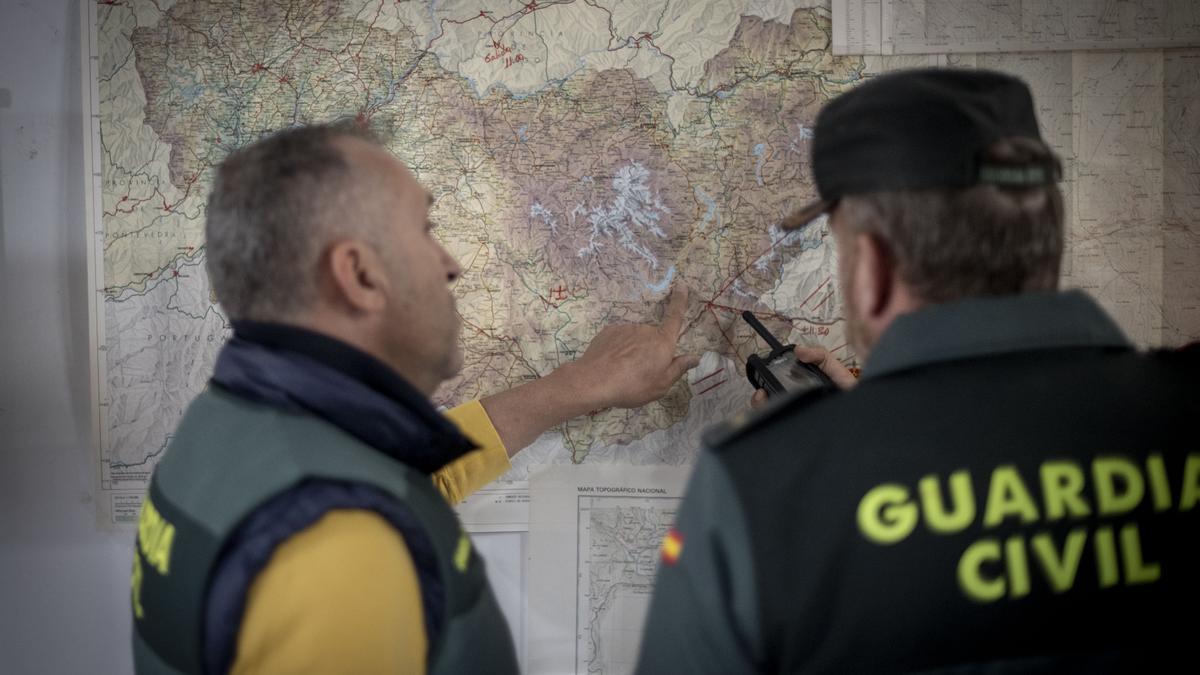 Agentes de la Guardia Civil examinan el mapa con las zonas de referencia para buscar la avioneta.
