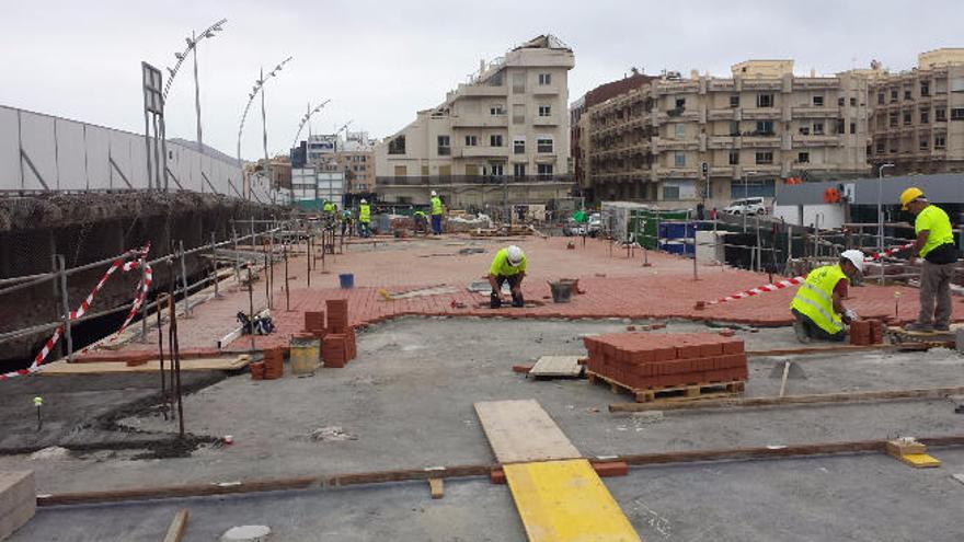 Obreros durante la colocación del empedrado urbano.