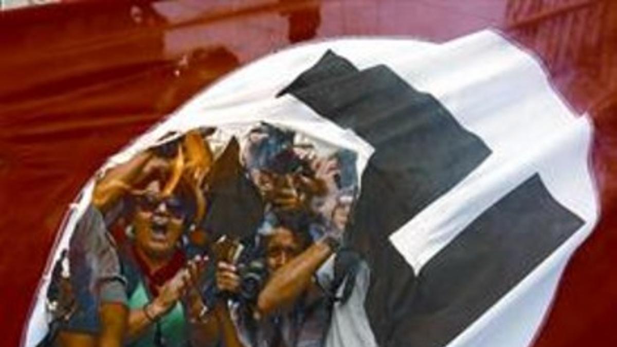 Unos manifestantes queman una bandera nazi en una visita de Merkel a Atenas, en el 2012.