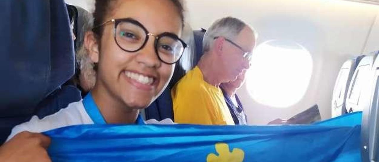 Daniela Morales, en el avión a Canadá, con una bandera asturiana.