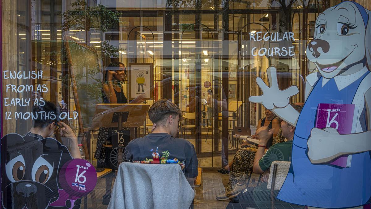 Una profesora imparte clase de inglés a varios estudiantes, en una academia de Barcelona