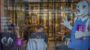 Una profesora imparte clase de inglés a varios estudiantes, en una academia de Barcelona