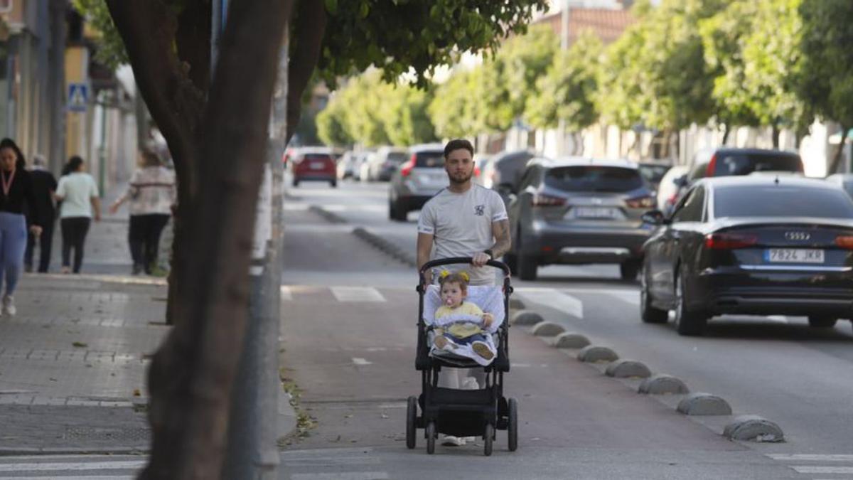 Un padre y su hija por el carril bici de la calle principal.