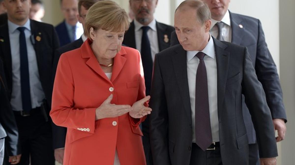 Angela Merkel y Vladimir Putin hablan, el pasado 13 de julio en Río, antes de la final del Mundial de fútbol.