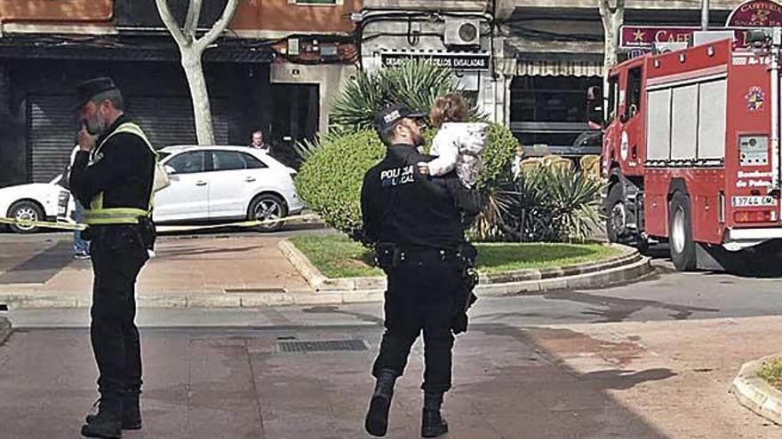 Un policÃ­a sostiene a un bebÃ© tras un incendio en un aparcamiento.