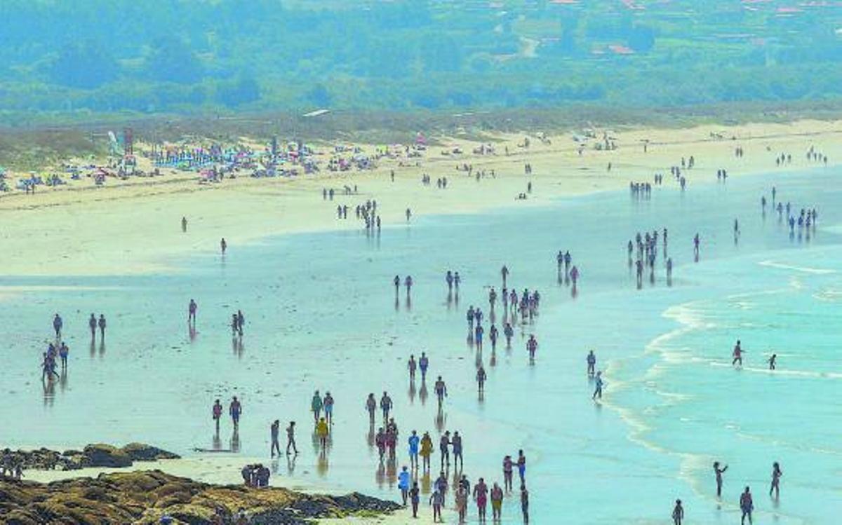 Bañistas en la playa de A Lanzada el pasado verano.   | // IÑAKI ABELLA
