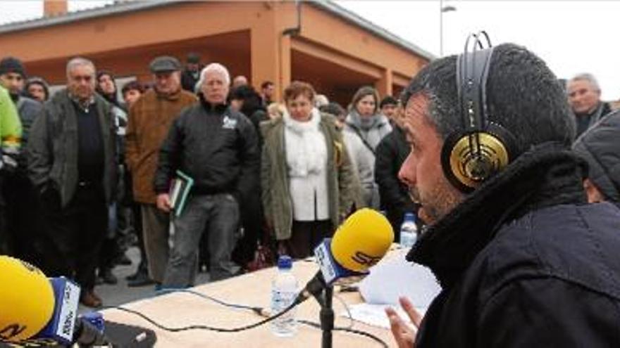El conseller de Territori, Santi VIla, en primer terme, participant en un programa de ràdio i els veïns al fons.