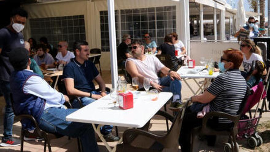 Pla general d&#039;un grup de persones assegudes en una terrassa d&#039;un bar del passeig marítim de Coma-ruga, al Vendrell aquest Divendres Sant