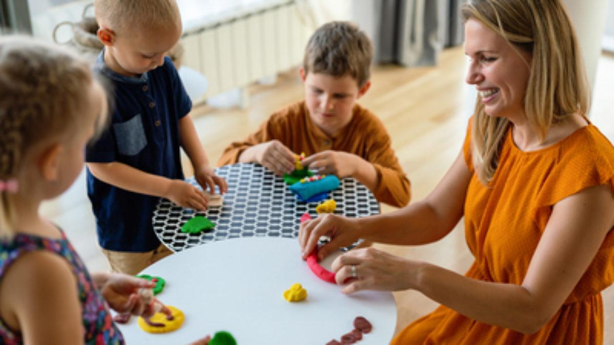 Family activities in the kids room. Woman and children playing together.