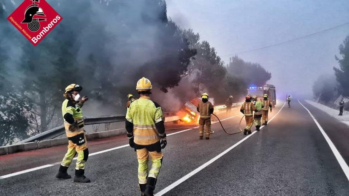 Efectivos de bomberos sofocan el incendio de un vehículo en Benimantell.