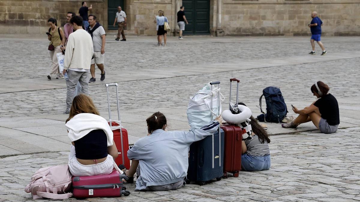 Turistas con maletas en la Praza do Obradoiro de Santiago