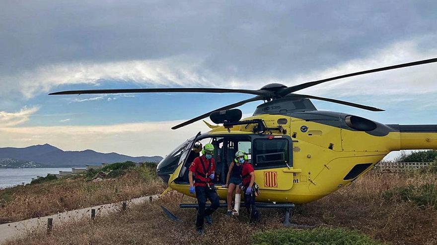 Els Bombers amb l&#039;helicòpter atenent la rescatada.