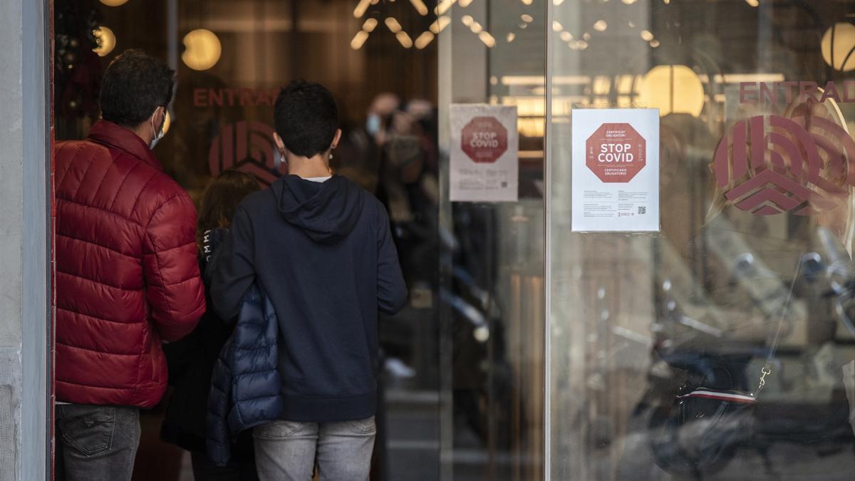 Varias personas acceden a una tienda en Valencia.