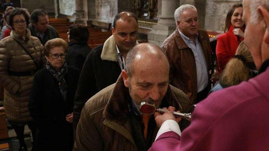 Los asistentes a la misa propiciada por la ONCE besan la reliquia de Santa Lucía.