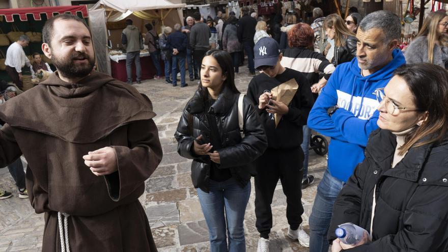 El guia vestit de frare parla de la configuració triangular de la plaça Major al grup de visitants que va fer la ruta guiada ahir al migdia