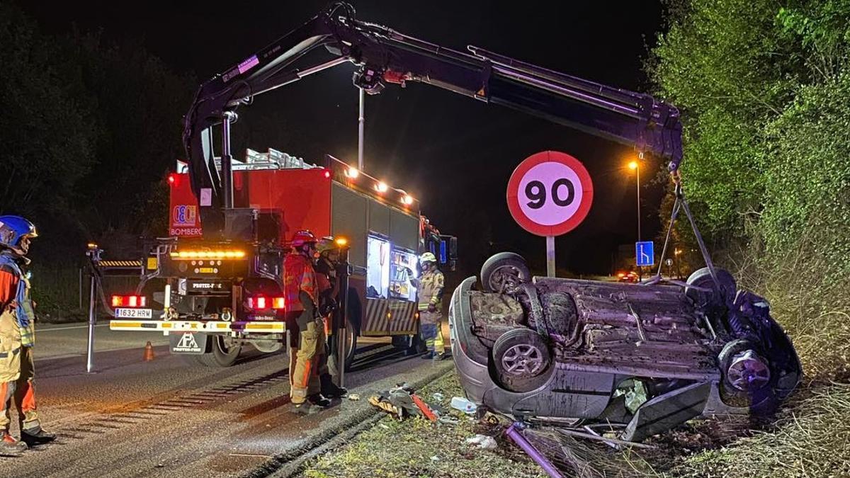 Los bomberos, dando vuelta al vehículo volcado en la noche del jueves.