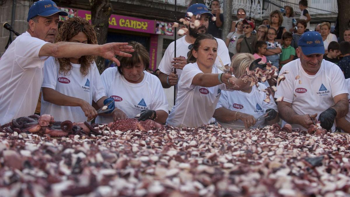 Un grupo de personas prepara una tapa gigante de pulpo en la cita carballinesa. |   // IÑAKI OSORIO