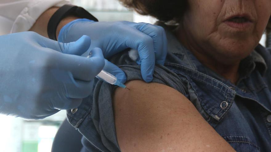 Una mujer recibiendo la vacuna de la gripe.