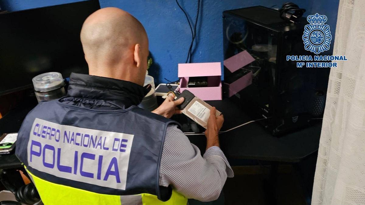Imagen de un agente manipulando un dispositivo electrónico.