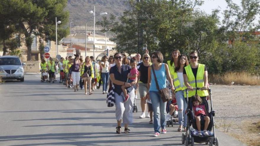 Madres y niños andando por la carretera