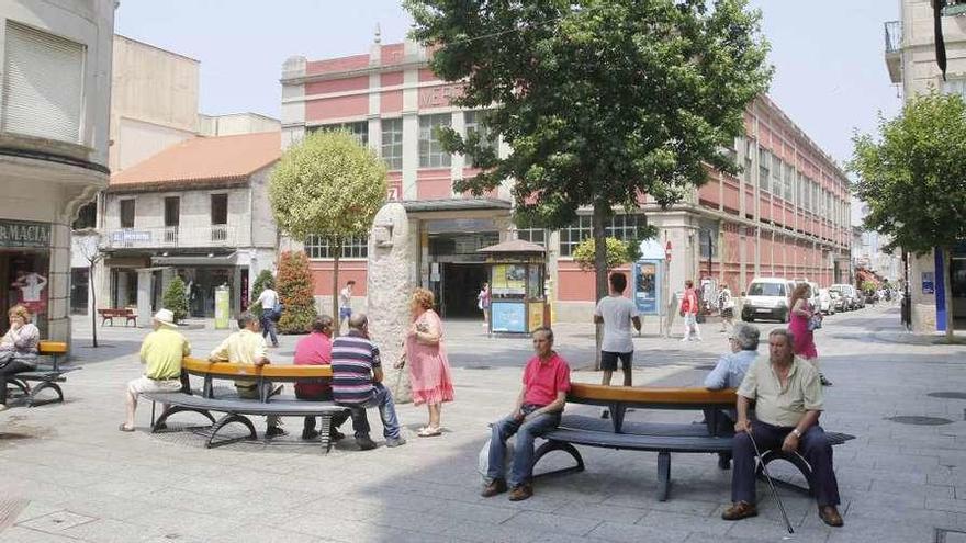 Un grupo de vecinos ayer en el paseo peatonal de O Calvario, delante del mercado del barrio. // Alba Villar