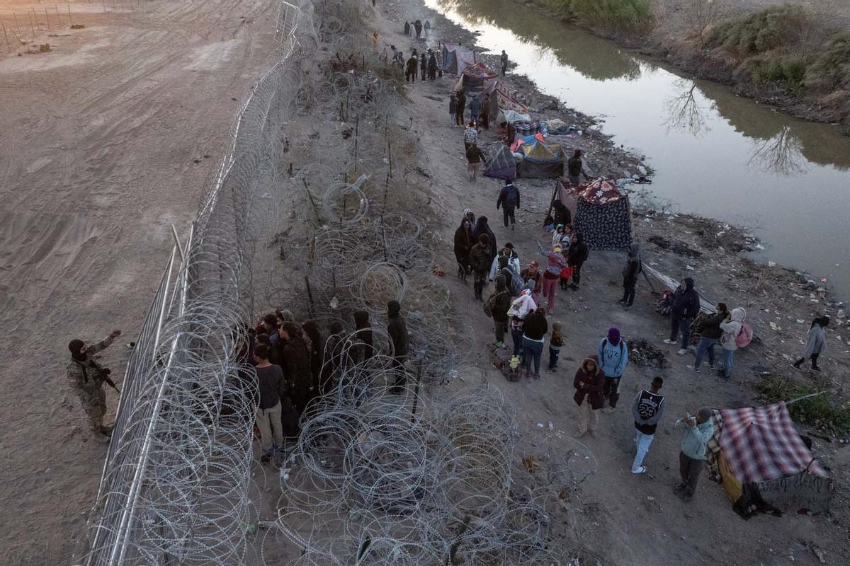 Migrantes acampan a lo largo de la orilla del río Grande mientras esperan entregarse a las autoridades de inmigración en El Paso, Texas, EE.UU