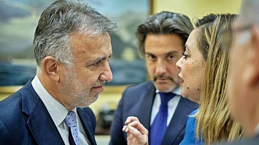 El secretario general del PSOE canario, Ángel Víctor Torres, conversa con Dolores Corujo en los pasillos del Parlamento.