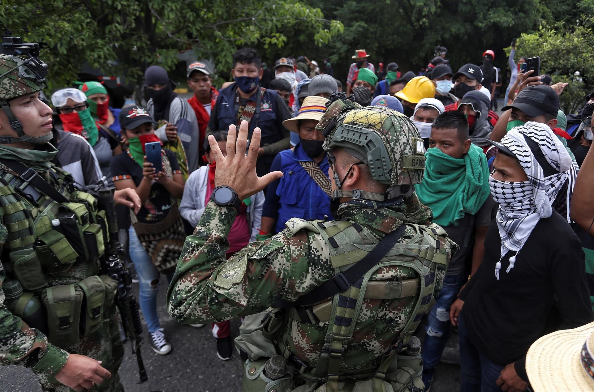 Soldados dialogan con manifestantes indígenas en Cali en la movilización de este domingo.