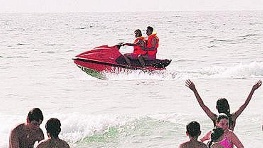 Dos socorristas en la playa de Xagó, a bordo de una moto acuática.