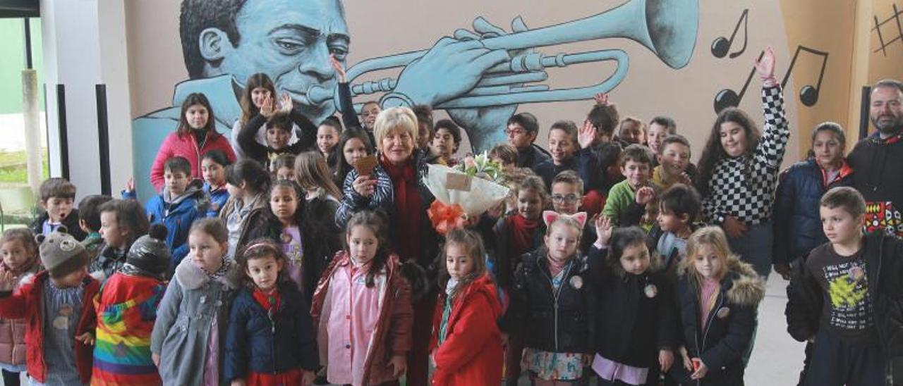 Alumnado del colegio de Luíntra con Celita, sobrina de José María, en el centro con el ‘chifre’ de su tío, y al fondo el mural de Miles Davis.   | //  IÑAKI OSORIO