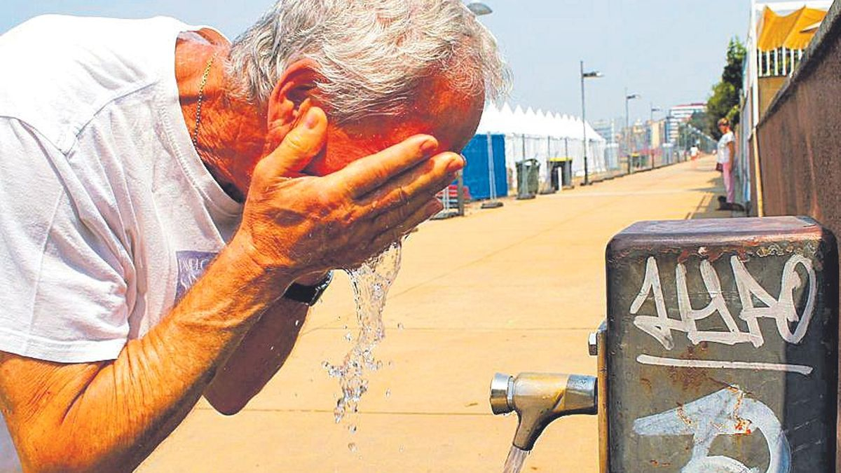 Un hombre se refresca en una playa.