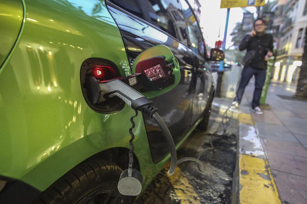 Un conductor recargando la batería de su coche eléctrico en una calle de Alicante.