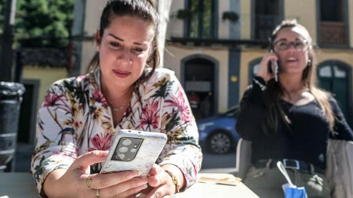 Una joven utiliza su móvil sentada en una terraza.