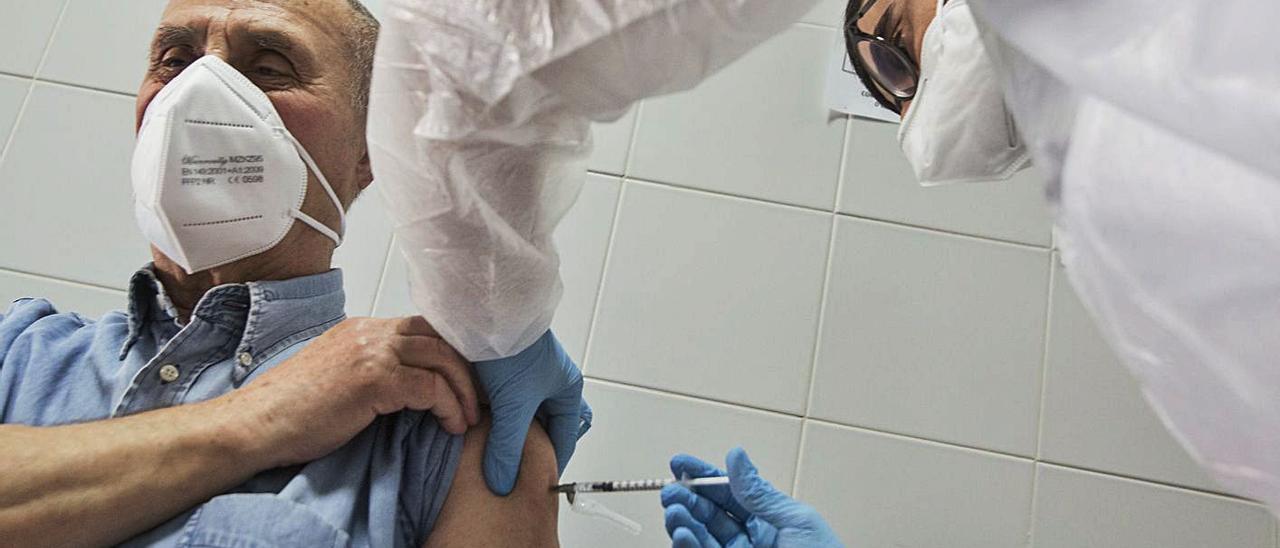 Un enfermero inyectando la vacuna contra el covid a un hombre. |