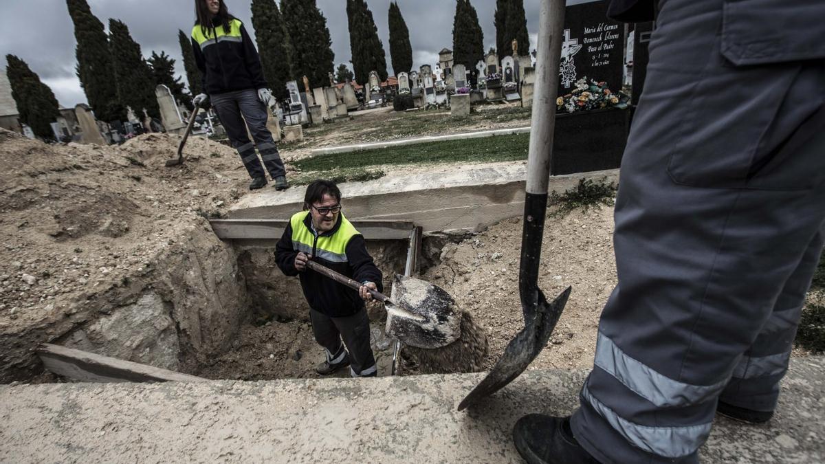 Operarios preparan una sepultura en el cementerio de Alcoy.