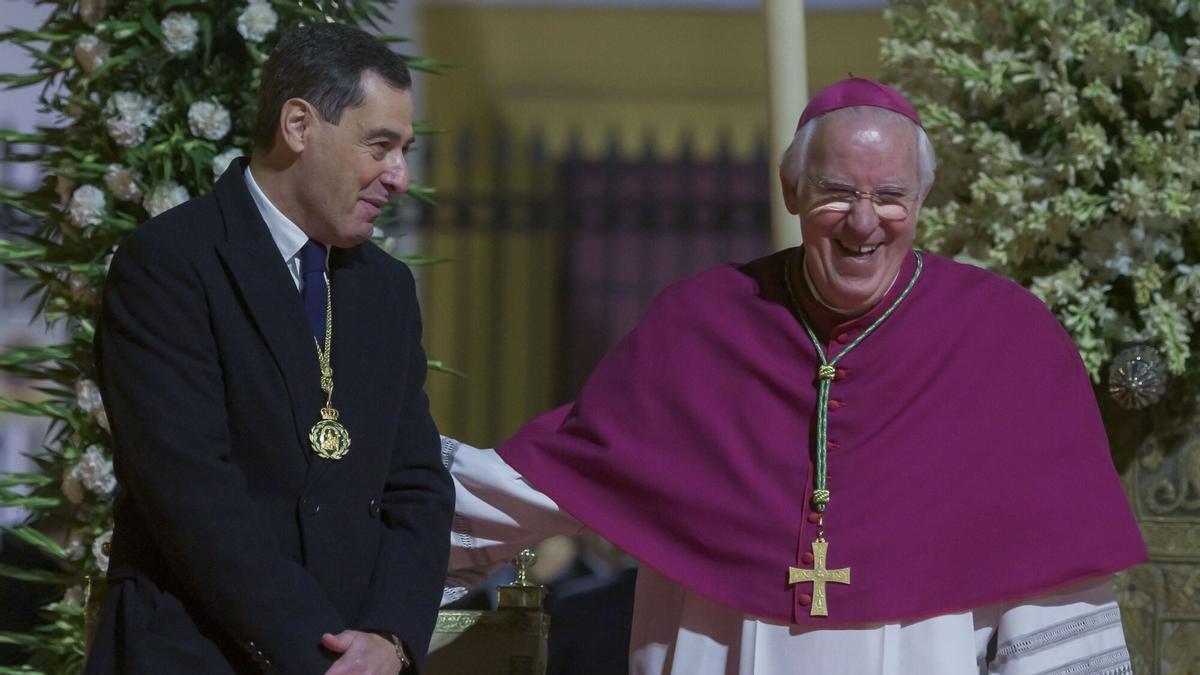 El presidente de la Junta de Andalucía, Juanma Moreno, y el Arzobispo de Sevilla, Monseñor José Ángel Saiz Meneses, en el Palco de Autoridades de la Magna.