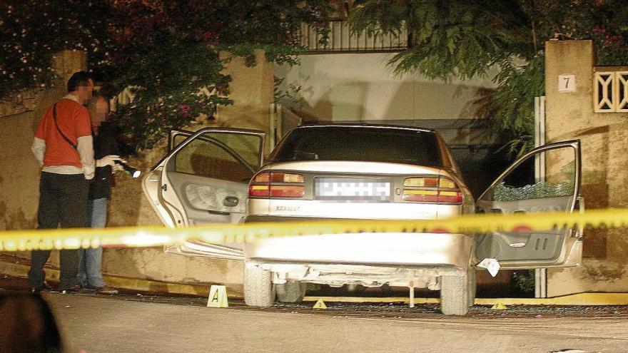 Dos agentes junto al coche de Alejandro Ponsoda en el lugar donde fue tiroteado.