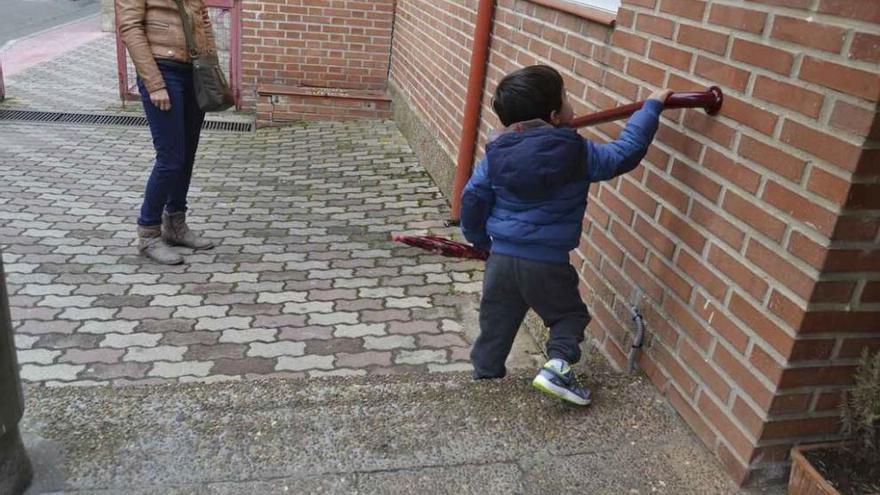 Un niño se agarra a la nueva barandilla para bajar mejor las escaleras.