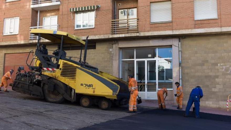 Varios operarios realizan labores de asfaltado en la calle Las Eras.